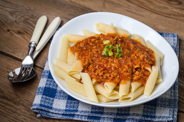 Pasta penne with tomato bolognese sauce.