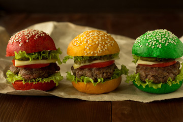 Green, yellow and red burger on wooden table