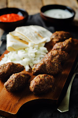 Minced meat sausage with onion, sour cream, pita and red bell pepper relish