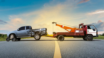 Tow truck delivers the damaged vehicle, Sun light flare, Selective focus