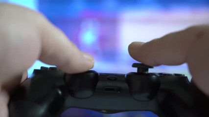 POV of a man with gamepad controller in his hands playing video game in front of TV screen - Powered by Adobe