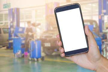 closeup of man with broken car and smart phone, Man hand holding mobile smart phone , tablet,cellphone over Blurred of car technician repairing the car in garage background,vintage color.