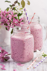 Obraz na płótnie Canvas Berry smoothie or milkshake in jar on white wooden rustic background