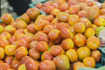 Baskets of red cherry tomatoes for sale at a farmer's market,Close up of fresh organic tomatos at outdoor market,heap of tomatoes,Just harvested tomatoes for sale at local farm market,selective focus.