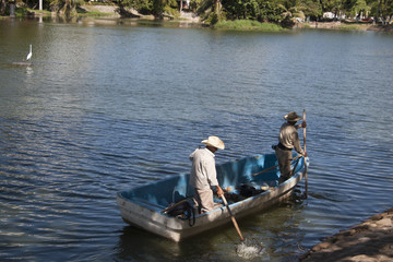 Fototapeta na wymiar Two man on boat. Lagoon of illusions, Tomas Garrido Canabal Park, Villahermosa, Tabasco, Mexico.