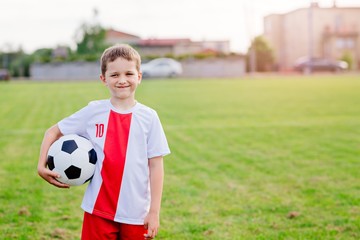 Naklejka premium 8 years old boy child holding football ball