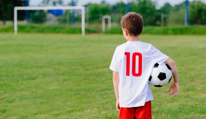 8 years old boy child holding football ball