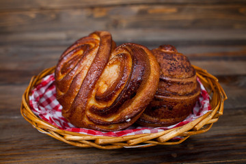 Delicious, fresh pretzels in wicker basket on wooden background