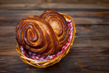 Delicious, fresh pretzels in wicker basket on wooden background