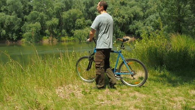 A man on a bicycle by the river. Active rest on a bicycle.