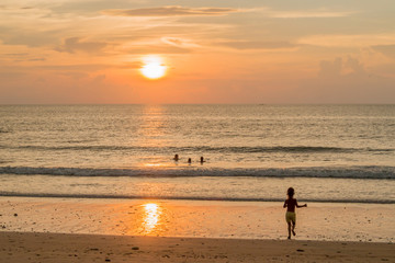 Fototapeta na wymiar Child runing to the sunset beach (Ko Lanta Thailand)