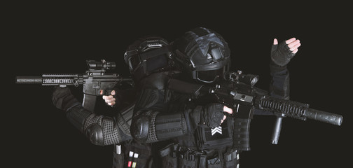 Members of the SWAT squad with an assault rifle in a black uniform on dark background. Special...
