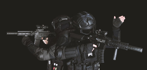 Obraz premium Members of the SWAT squad with an assault rifle in a black uniform on dark background. Special weapons and tactics. Special Forces.