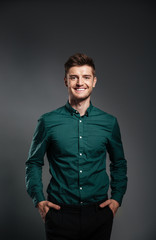 Man in shirt standing with hands in pockets