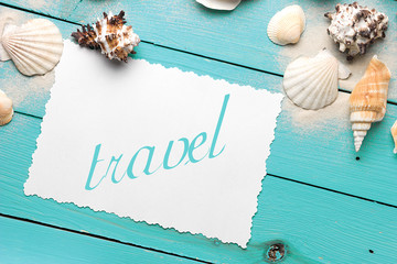 Marine summer postcard. Seashells on turquoise wooden boards in the sand on the beach