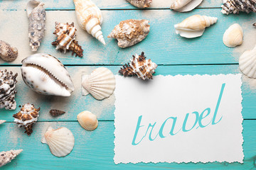 Marine summer postcard. Seashells on turquoise wooden boards in the sand on the beach