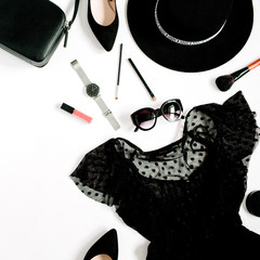 Trendy fashion black styled woman clothes and accessories collection on white background. Flat lay, top view. Dress, high heels, sunglasses, purse, watches.