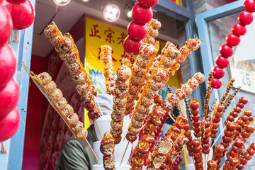 stall with caramelized fruit on stick on street