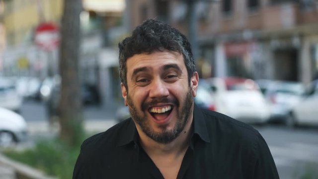  portrait of Happy latin bearded  Man laughing On Street