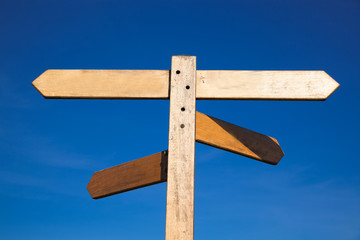 empty wooden signboard against blue sky