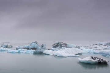 Big blue icebergs in Jokulsarlon glacier lake lagoon in the mist. Iceland.