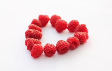 Big juicy sweet raspberries in shape of a heart
