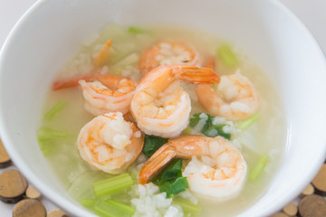 Shrimp porridge,Rice porridge with shrimp in white bowl,Porridge rice with shrimps and fried garlic. white colors fabric background,selective focus
