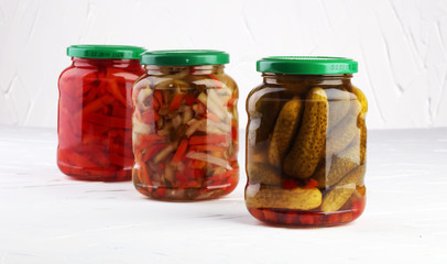 Jar with variety of pickled vegetables. Carrots, field garlic, cucumber in glas. Preserved food