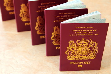 Five British United Kingdom European Union Biometric passports standing in a row