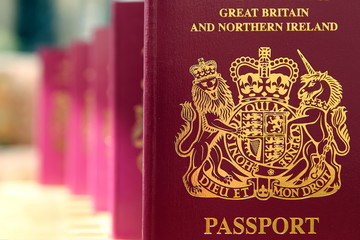 Five British United Kingdom European Union Biometric passports queueing in a line in shallow focus