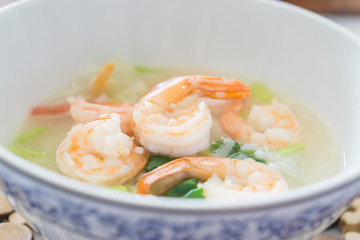 Shrimp porridge,Rice porridge with shrimp in white bowl,Porridge rice with shrimps and fried garlic. white colors fabric background,selective focus