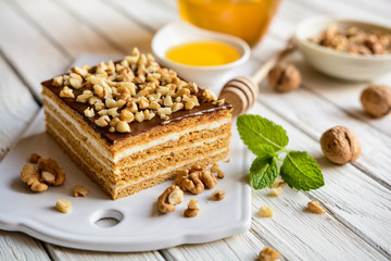 Delicious layered honey cake with chocolate and walnut topping