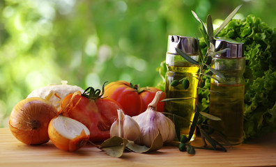 Olive oil,vinegar, tomato and herbs on rustic table