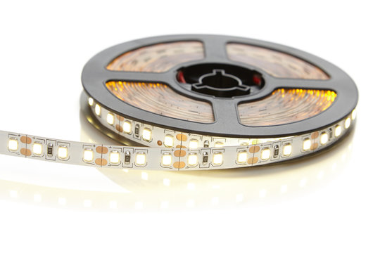 Reel of a diode strip with warm light on a white background