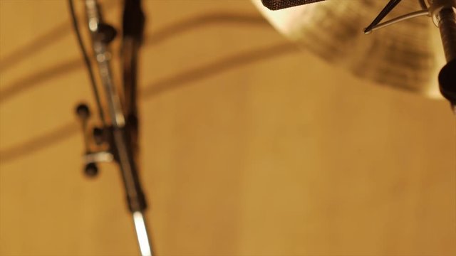 pan over microfon and cymbal towards background, cymbal hit in between