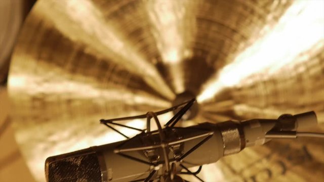 pan over microfon and cymbal towards background, cymbal hit in between