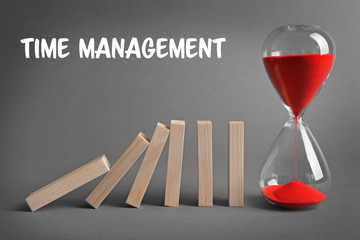 Hour glass blocked row of falling dominoes on grey background