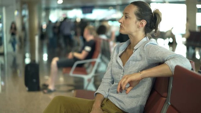 Impatient woman waiting for plane at the airport
