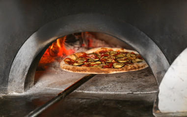 Tasty pizza putting out from oven
