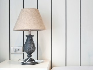 Vintage lamp on white table side in the bedroom. Concept for room interior and decoration.