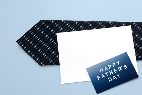 Men's Tie with paper card on a blue background. Happy Father's Day. Greeting card. Dad Gift.