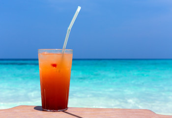 Cocktails in glass on white sandy beach