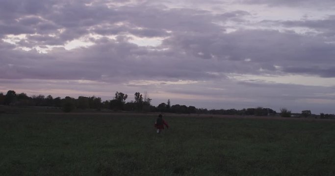 Little kid runs away in field, slow motion