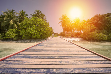 Naklejka na ściany i meble Tropical travel destinations with Maldives island and wooden wharf