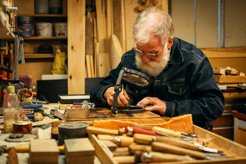 Senior wood carving professional during work