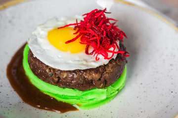 Close-up of green mashed potatoes, beef cutlets, fried eggs, beets, original, trendy, new serve, restaurant, beautiful, tasty food, top view