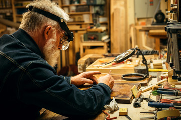 Senior wood carving professional during work