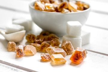 variety of sugar in bowls on white wooden table background