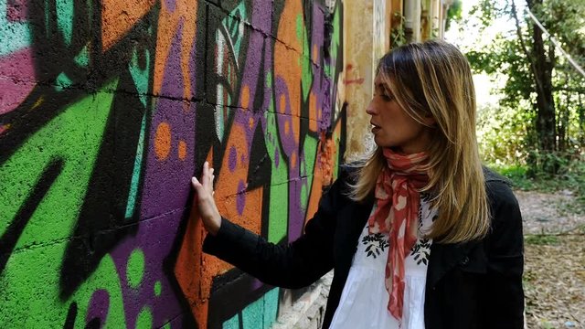beautiful Woman Walk observing graffiti wall, portrait