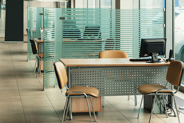 Workplace in the office of the car center pavilion. A computer table, panoramic windows, glass...